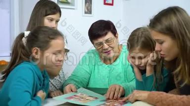 祖母和四个孙女在家看<strong>旧相册</strong>
